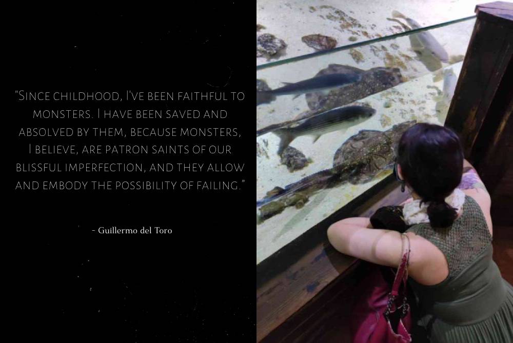 a picture of me seen from behind, wearing a long olive green dress with a knitted overlay on top. i'm crouching down in front of an aquarium tank and looking at the fish.