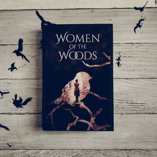 cover of women of the woods showing a woman standing on a forest path as seen through the silhouette of a bird.